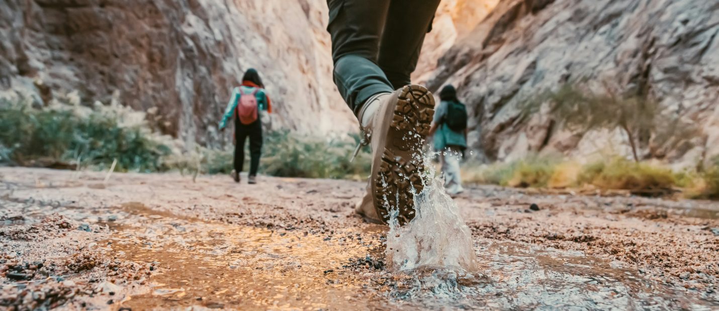Hiking boot walking through a puddle with a splash